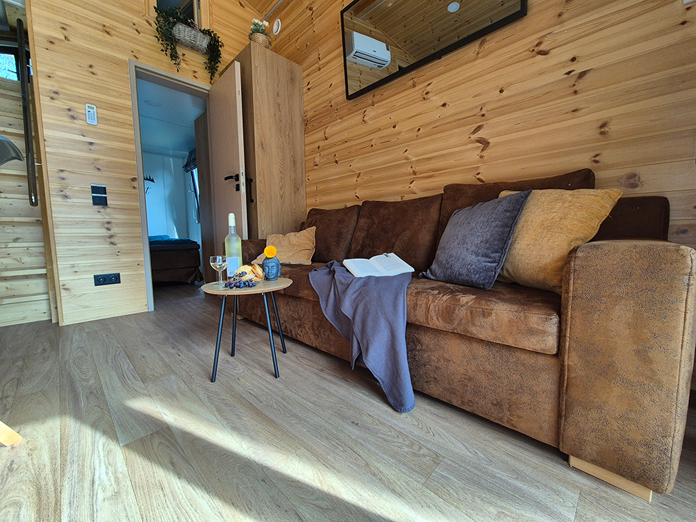 Blick vom gemütlichen Wohnzimmer-Sofa in das angrenzende Schlafzimmer mit Ostblick im modernen vollklimatisiertem Holz-Alpenchalet in der Nähe des Spitzingsees.